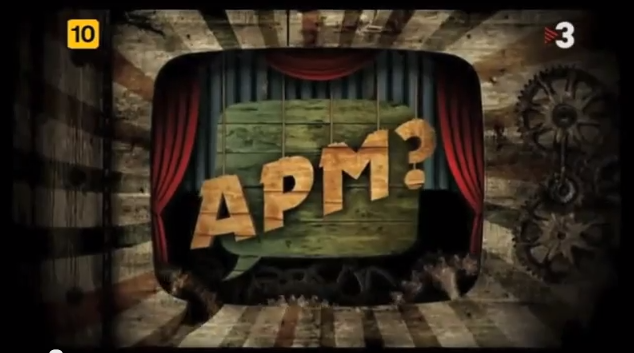 Fotograma del programa «APM?» de TV3, amb el logotip sobre un escenari de cortines vermelles.