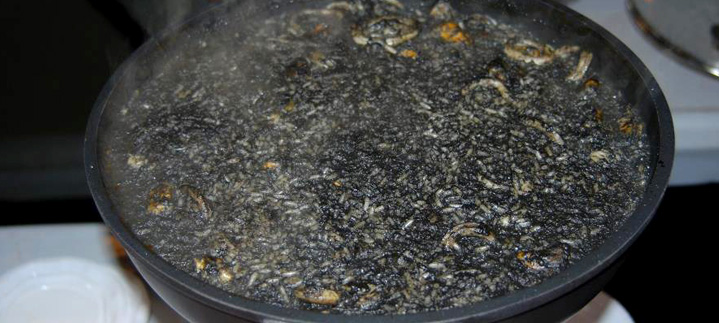 Una paella gran d'arròs negre acabada de coure.