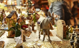 Figures d'un diorama de pessebre: un ase i diverses casetes en miniatura.