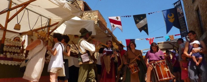 Parades i banderoles del Mercat Medieval amb visitants.