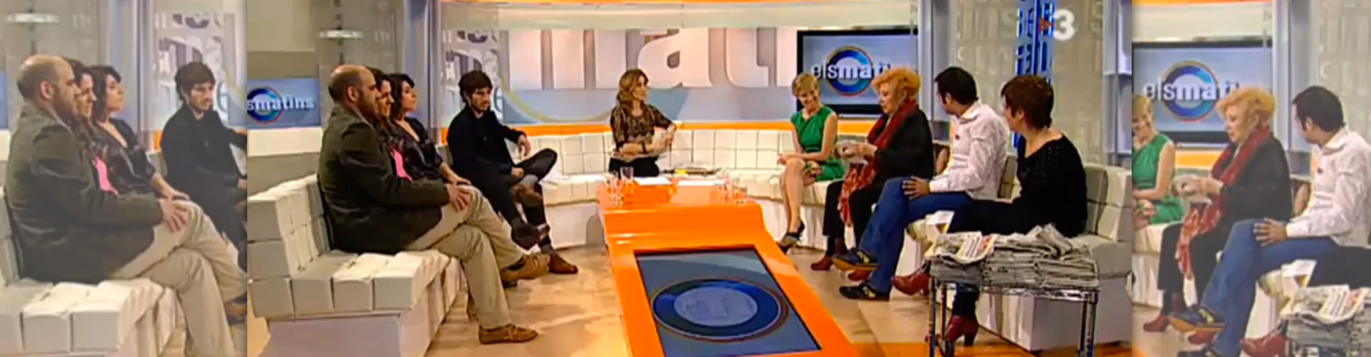 Plató de televisió amb els convidats asseguts en semicercle durant un programa en directe.