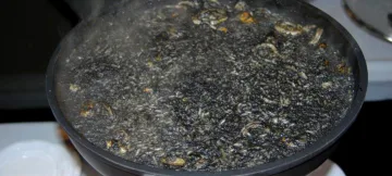 Una paella gran d'arròs negre acabada de coure.