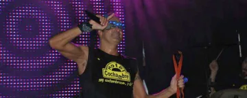 Un cantant amb samarreta d'Hotel Cochambre canta en un concert nocturn.