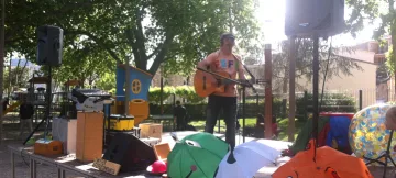 Un músic toca la guitarra a l'aire lliure durant les activitats infantils de diumenge.